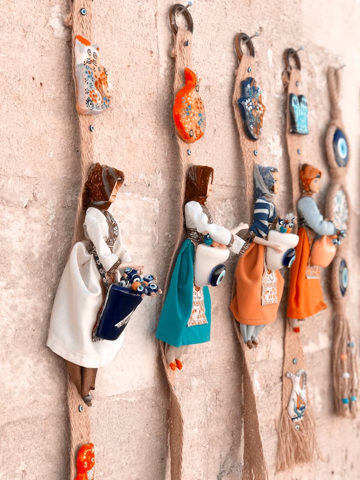Close-up of traditional handmade decorative dolls hanging on a wall.