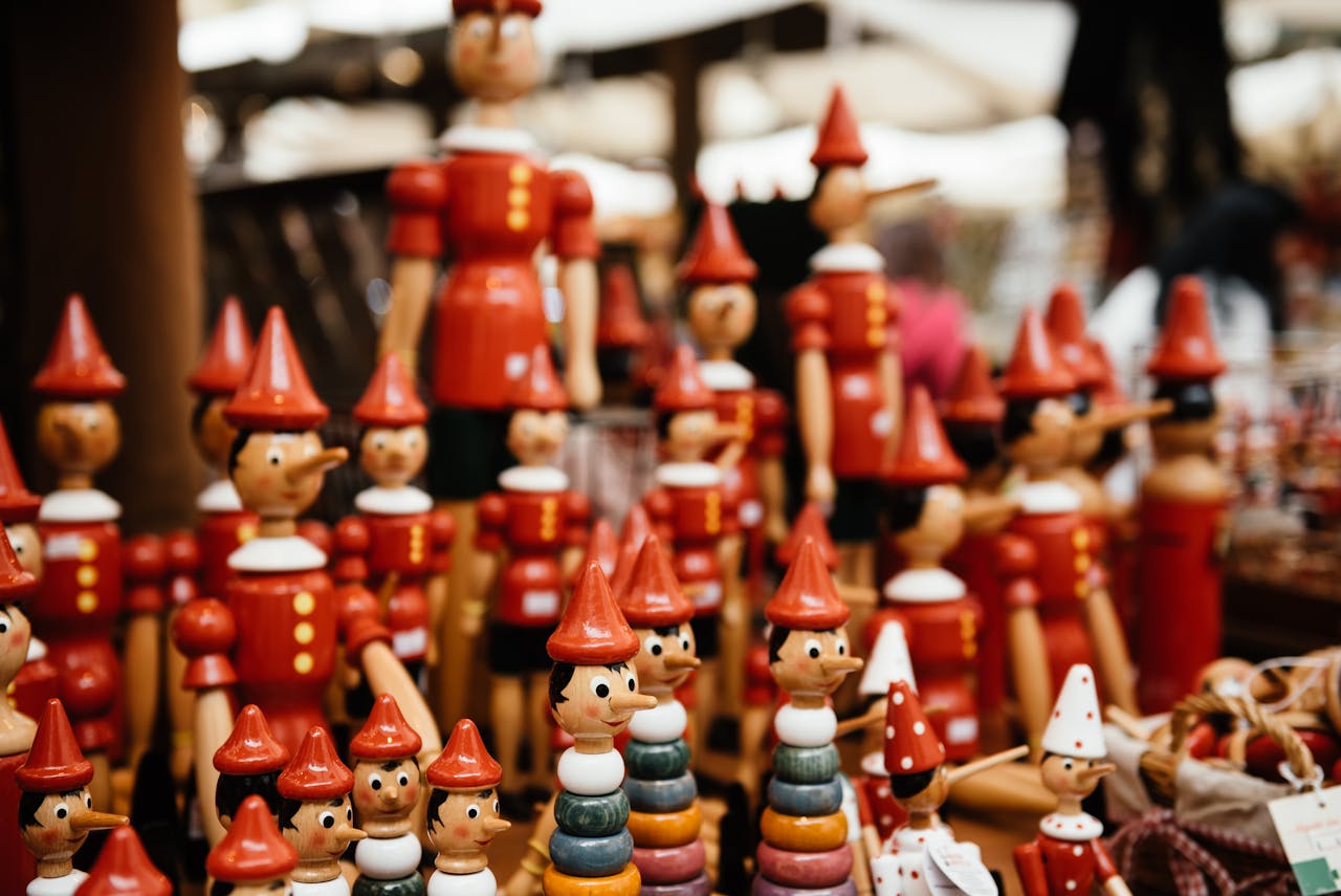 gallery-05 Close-up of handmade wooden Pinocchio toys at a market. Perfect for traditional and souvenir themes.